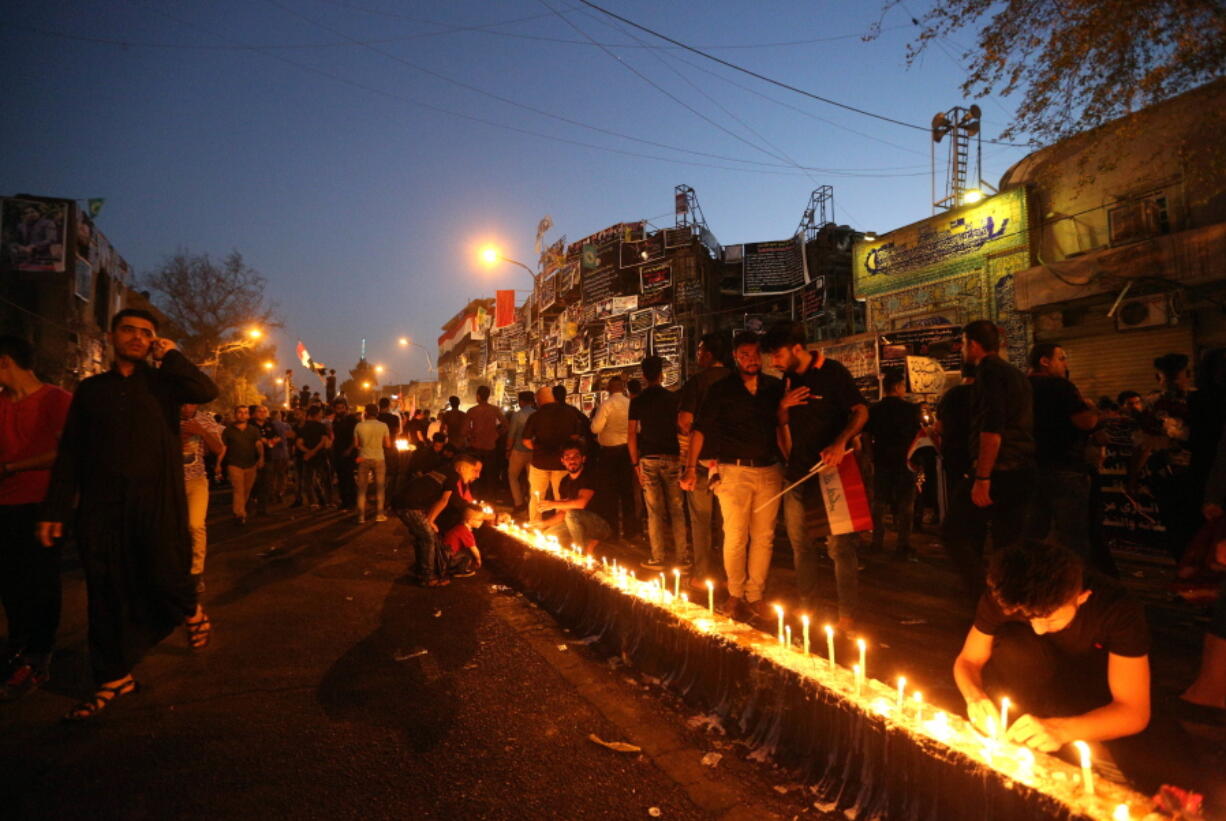 People light candles Wednesday at the scene of Sunday&#039;s massive truck bomb attack in the Karada neighborhood of Baghdad, Iraq.