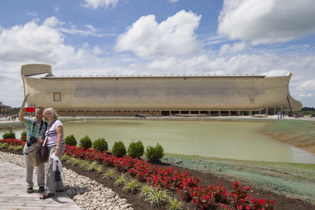 Visitors take a selfie as a replica Noah&#039;s Ark stands in the distance at the Ark Encounter theme park during a media preview day Tuesday in Williamstown, Ky. The long-awaited theme park based opened Thursday.