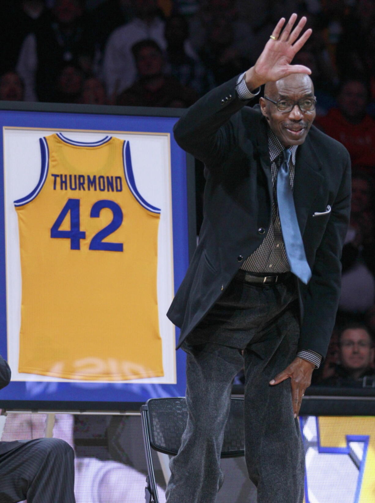 Former Golden State Warriors player Nate Thurmond waves during a halftime ceremony in 2012. The Hall of Fame center died Saturday.