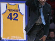 Former Golden State Warriors player Nate Thurmond waves during a halftime ceremony in 2012. The Hall of Fame center died Saturday.