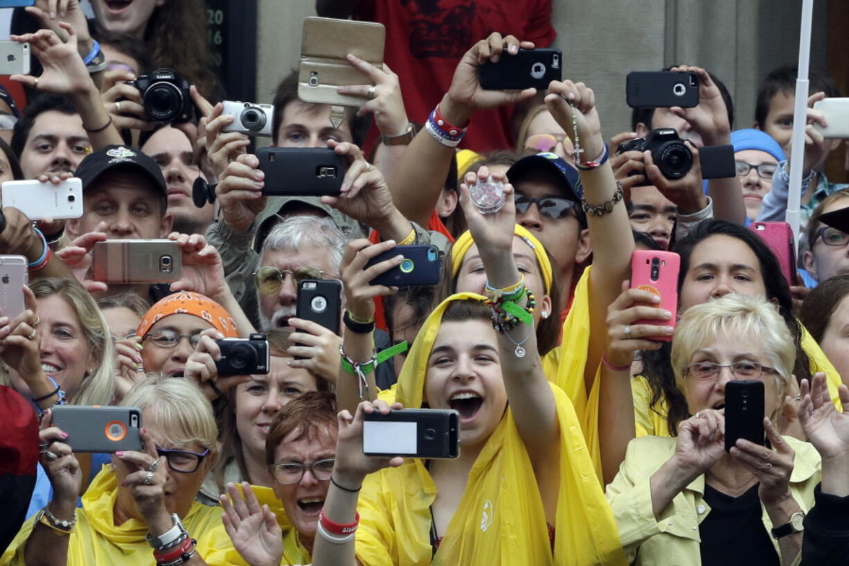 Faithful cheer and take pictures and videos with their phones of Pope Francis arriving by tram in Krakow&#039;s Jordan Park, Poland, on Thursday. The Pope is on a five-day visit to Poland which will culminate with the World Youth Day on Sunday.