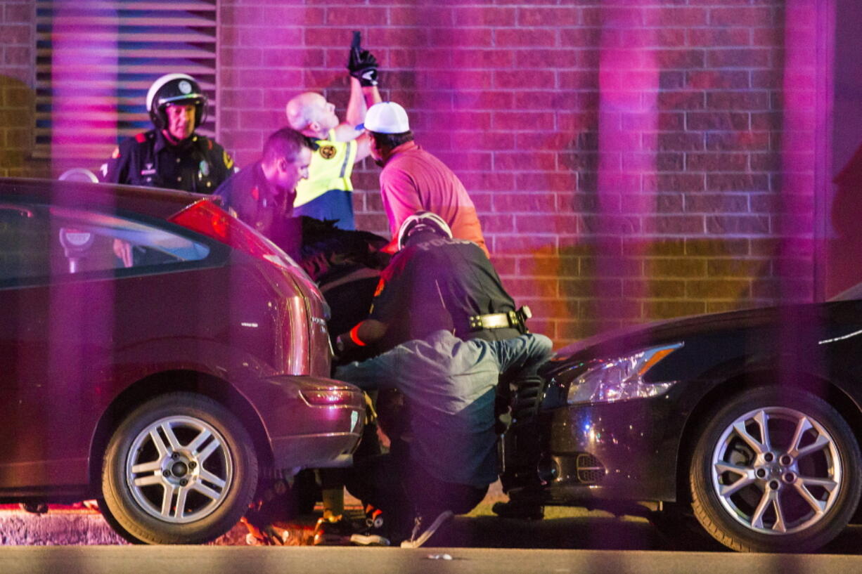 Dallas Police shield bystanders after shots were fired Thursday, July 7, 2016, during a protest over two recent fatal police shootings of black men. (Smiley N.