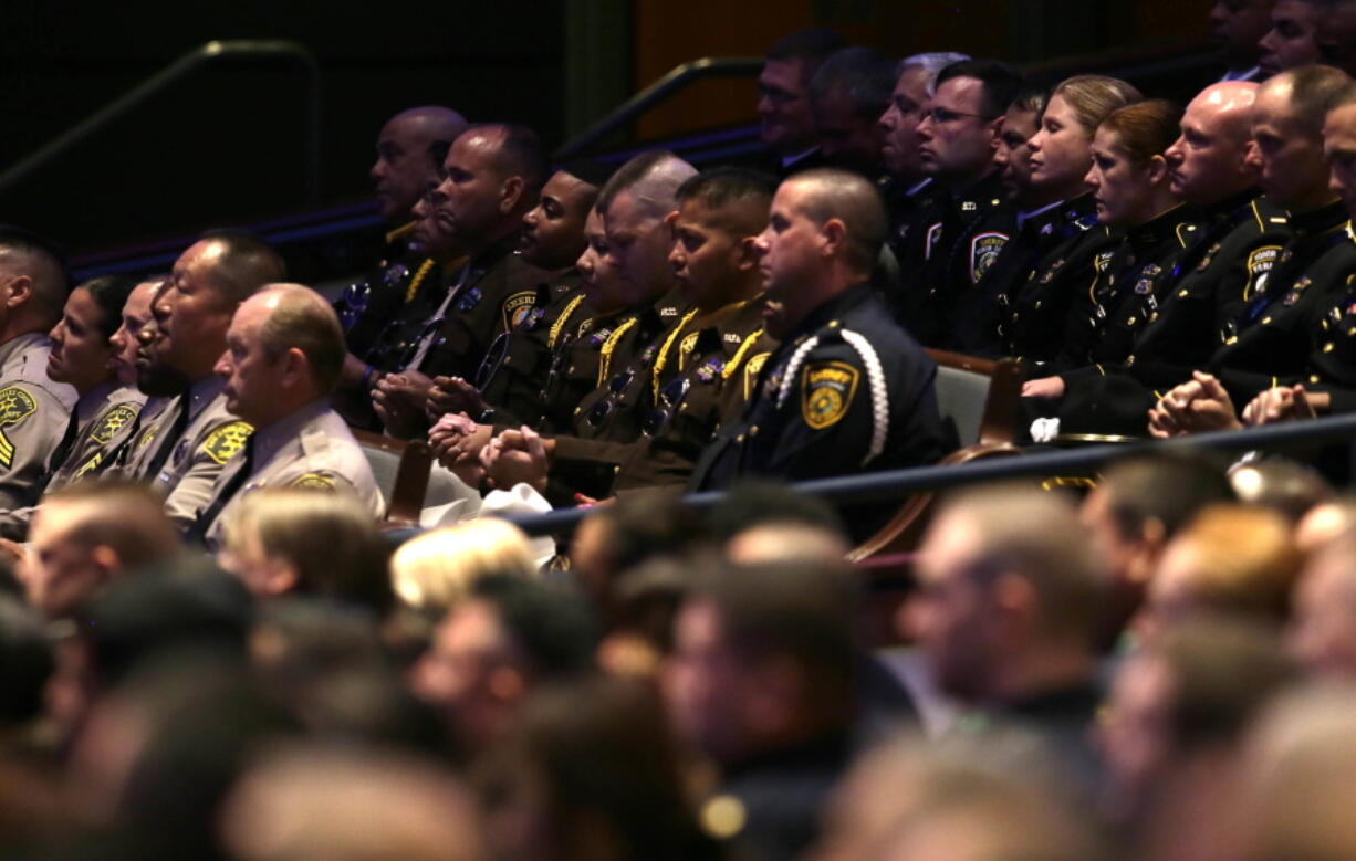 Law enforcement officers joined hands during the funeral services for Dallas Police Sr. Cpl. Lorne Ahrens at Prestonwood Baptist Church in Plano, Texas, on Wednesday. Ahrens and four other officers were slain by a sniper during a protest last week in downtown Dallas.