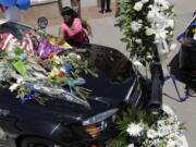 Cynthia Ware places flowers on a make-shift memorial at the Dallas police headquarters Friday in Dallas. Five police officers are dead and several injured following a shooting in downtown Dallas Thursday night.