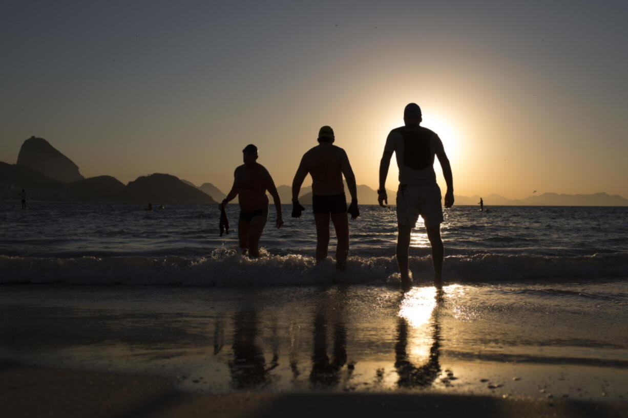 People enter the water for a morning swim at Copabacana beach in Rio de Janeiro, the starting point for the road cycling, marathon swimming and triathlon competitions.