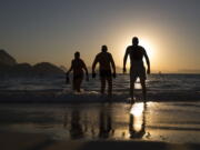 People enter the water for a morning swim at Copabacana beach in Rio de Janeiro, the starting point for the road cycling, marathon swimming and triathlon competitions.