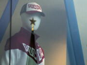 A mannequin dressed in a Russian Olympics National team uniform is on display in a shop window, with the Kremlin tower star reflected on a window glass, in Moscow, Russia, on Tuesday. The Executive Board of the International Olympic Committee meets Tuesday by teleconference to rule on what action to take against Russia for the mass doping program confirmed by the world anti-doping agency on Monday.