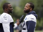 Seattle Seahawks' Michael Bennett, right, gets a pat from Cliff Avril during the team's NFL football training camp Saturday, July 30, 2016, in Renton, Wash.