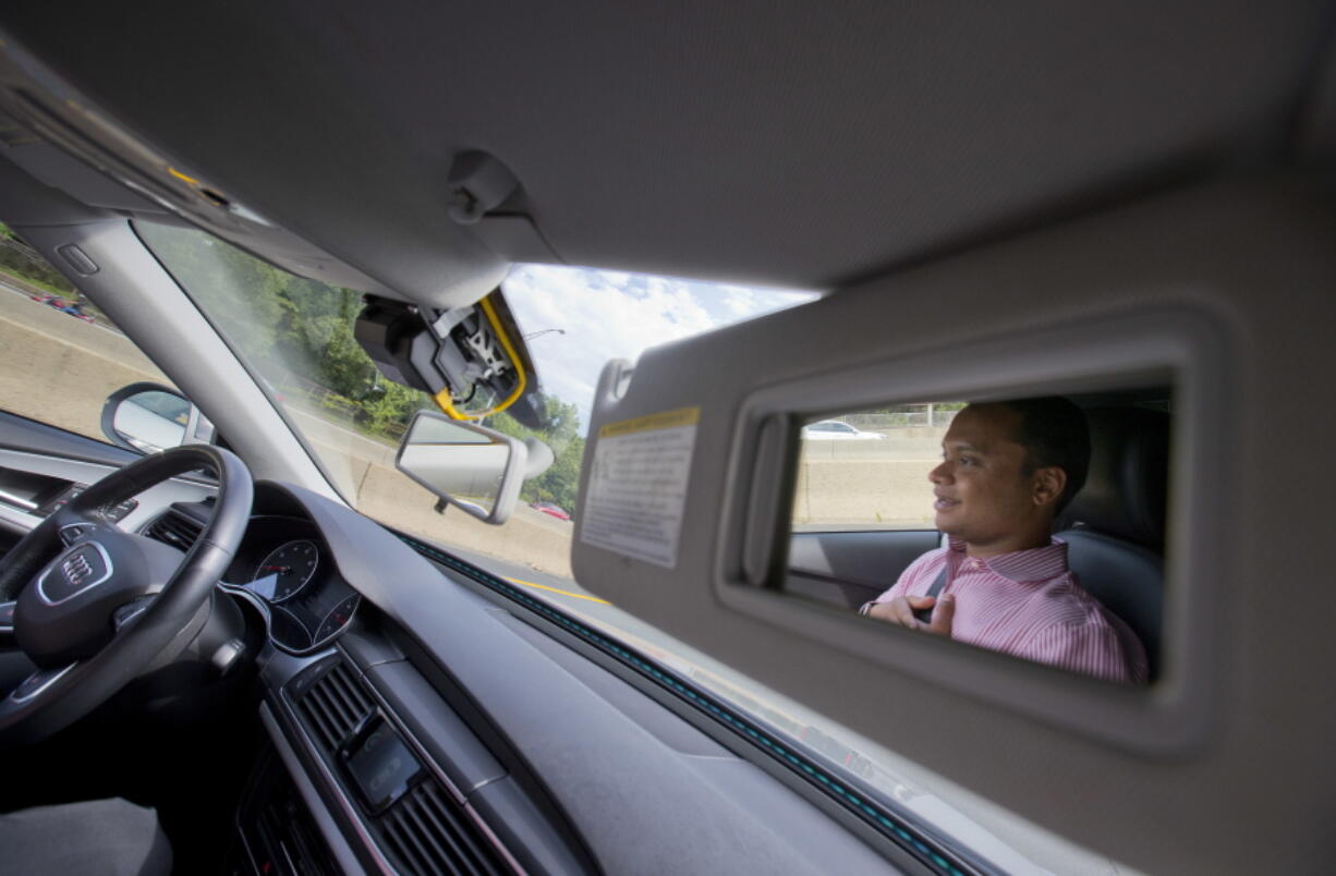 Kaushik Raghu, Senior Staff Engineer at Audi, is reflected in the passenger side visor mirror while demonstrating an Audi self driving vehicle on I-395 expressway in Arlington, Va., on Friday. Experts say the development of self-driving cars over the coming decade depends on an unreliable assumption by most automakers: that the humans in them will be ready to step in and take control if the car&#039;s systems fail. Experience with automation in other modes of transportation suggests that strategy will lead to more deaths like that of a Florida Tesla driver in May.