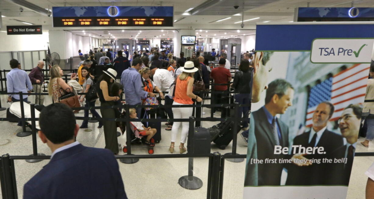 Travelers line up in May to pass through a Transportation Security Administration checkpoint at Miami International Airport in Miami.