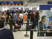 Travelers line up in May to pass through a Transportation Security Administration checkpoint at Miami International Airport in Miami.