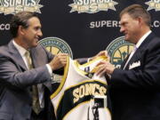 Howard Schultz, left, CEO of Starbucks Corp., presents a jersey to Oklahoma City businessman Clay Bennett after the Seattle SuperSonics were sold on July 18, 2006. (Ted S.