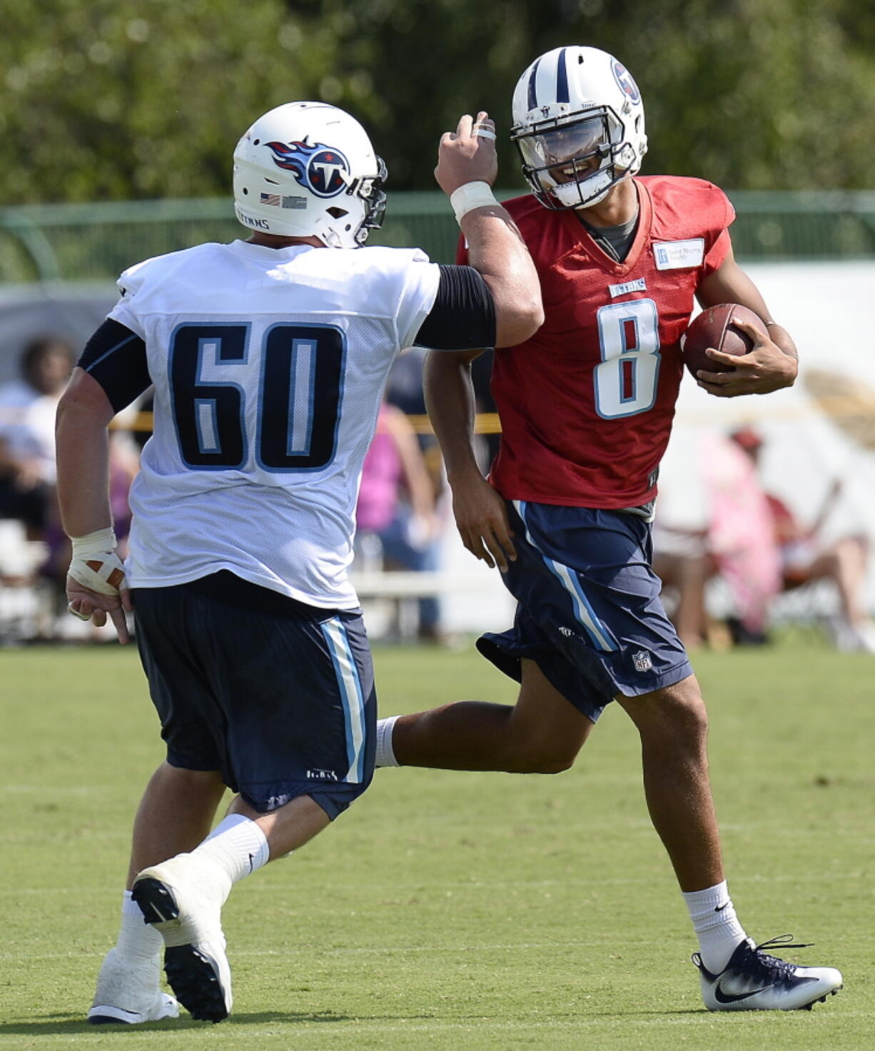 Tennessee Titans quarterback Marcus Mariota (8) celebrates with center Ben Jones (60) after running a play during NFL football training camp Sunday, July 31, 2016, in Nashville, Tenn.