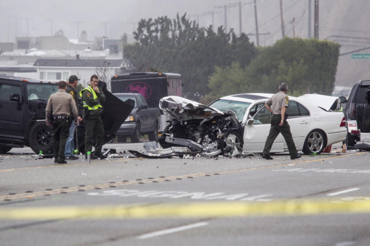 Los Angeles County Sheriff&#039;s deputies investigate the scene of a collision involving three vehicles in Malibu, Calif.  (AP Photo/Ringo H.W.