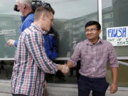 Joseph Backholm, left, executive director of the Family Policy Institute of Washington, shakes hands with Yes Segura, of the LGBTQ Allyship, after the two spoke following Segura&#039;s group&#039;s attempt to confront supporters of proposed Initiative 1515 on Thursday in Lynnwood.