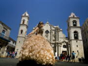 A &quot;quinceanera&quot; poses during her photo session in front of the cathedral as tourists line up to enter the building, in Havana, Cuba. Scheduled commercial airline service to Havana from 10 American cities won tentative government approval Thursday, advancing President Barack Obama&#039;s effort to normalize relations with Cuba.