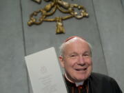 Cardinal Christoph Schoenborn holds a copy of the post-synodal apostolic exhortation &quot;Amoris Laetitia&quot; (&quot;The Joy of Love&quot;) during a press conference at the Vatican.