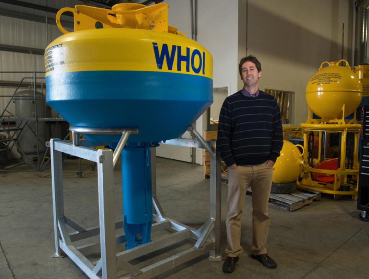 Mark Baumgartner of the Woods Hole Oceanographic Institution stands next to a whale buoy, a high-tech acoustic device that will eavesdrop on the songs of the whales, in Woods Hole, Mass.