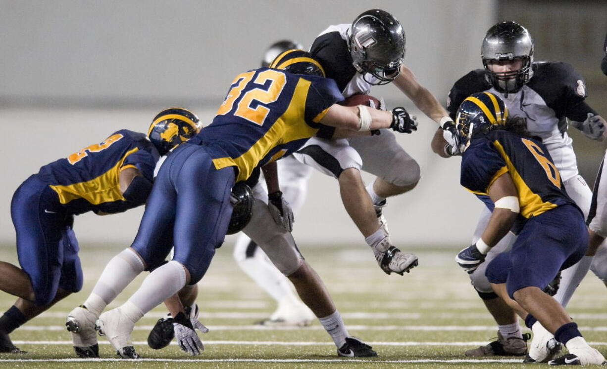 Union's Blake Russell leaps into Bellevue defenders in a 35-6 loss at the 3A State Football championsip game at the Tacoma Dome, Saturday, December 6, 2008.