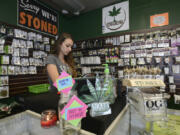 Alex Merrell, a manager at Sticky's Pot Shop in Hazel Dell, organizes merchandise Monday. The store must stop selling marijuana after Superior Court Judge Daniel Stahnke upheld a Clark County Hearings Examiner's decision.