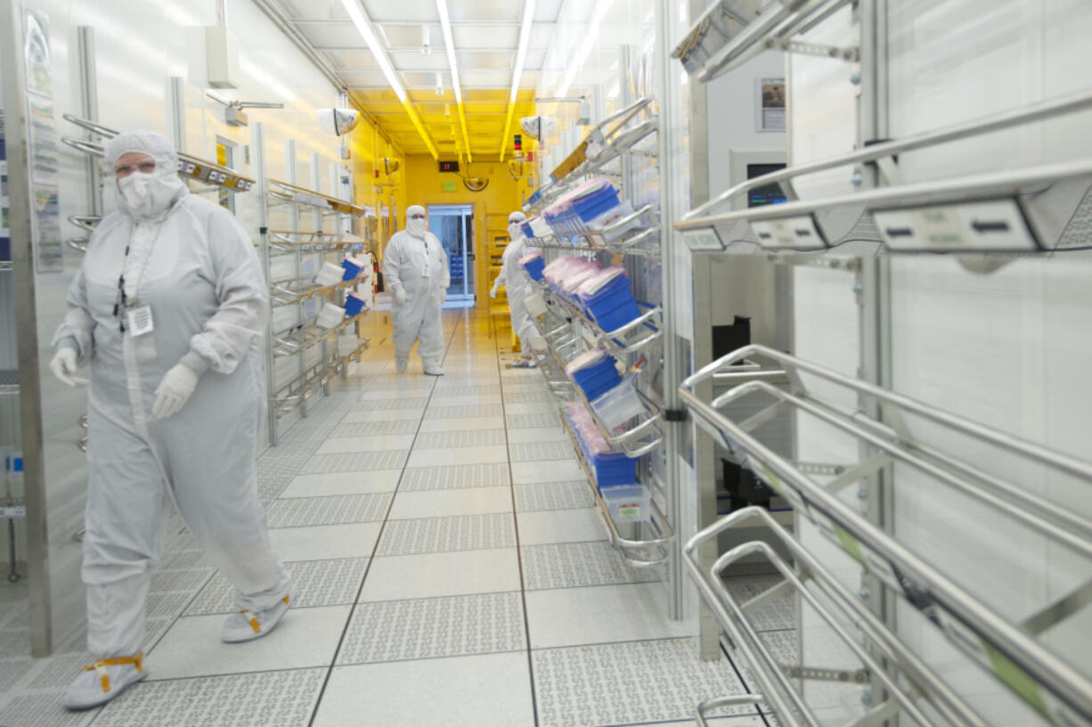 Linear Technology employees move through a corridor inside a clean room June 20, 2014. The semiconductor manufacturing plant in Camas employs 290 people.