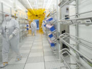 Linear Technology employees move through a corridor inside a clean room June 20, 2014. The semiconductor manufacturing plant in Camas employs 290 people.