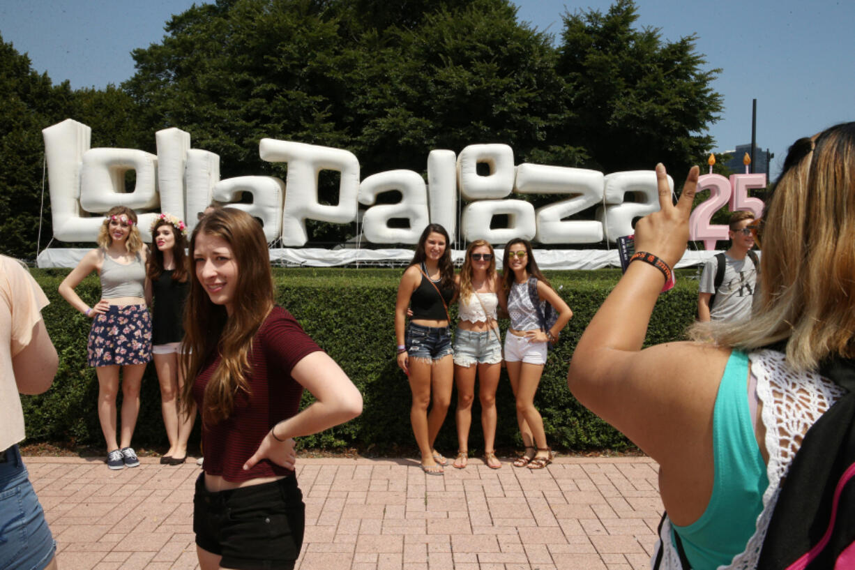 Festival goers pose for photos on the opening day of the Lollapalooza music festival July 28 at Grant Park in Chicago.