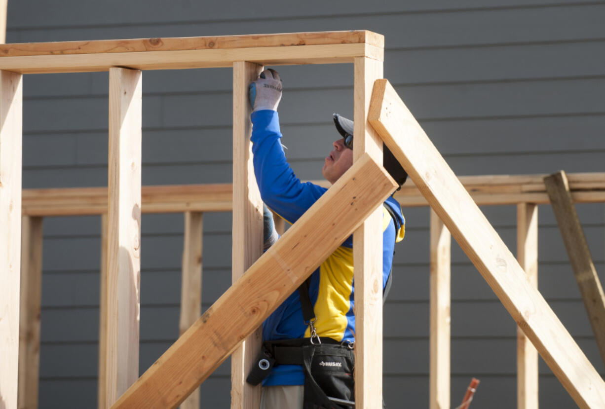 Carlos Salazar works framing a new home in Vancouver in October. The median home sale price in July dipped from June&#039;s record high but still managed to stay 5 percent above the average price of July 2015.