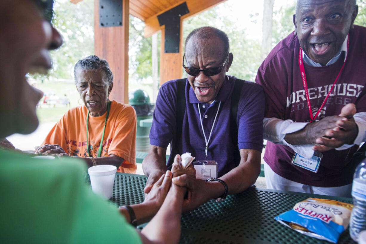 June Joaquin, from left, back, Bishop Joseph Cook Sr. and Maurice Word sing gospel hymns during a picnic at War Memorial Park in Martinsburg, W.Va. Camp Dynamite takes seniors on field trips.