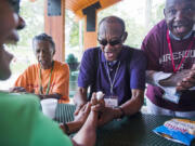 June Joaquin, from left, back, Bishop Joseph Cook Sr. and Maurice Word sing gospel hymns during a picnic at War Memorial Park in Martinsburg, W.Va. Camp Dynamite takes seniors on field trips.