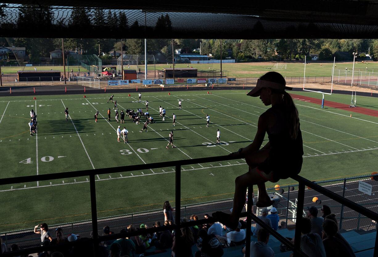 Battle Ground resident Andi Copper, 11, gets a birds-eye view of the field from her perch in the stands while taking in football action with fellow fans Thursday evening at Battle Ground High School.