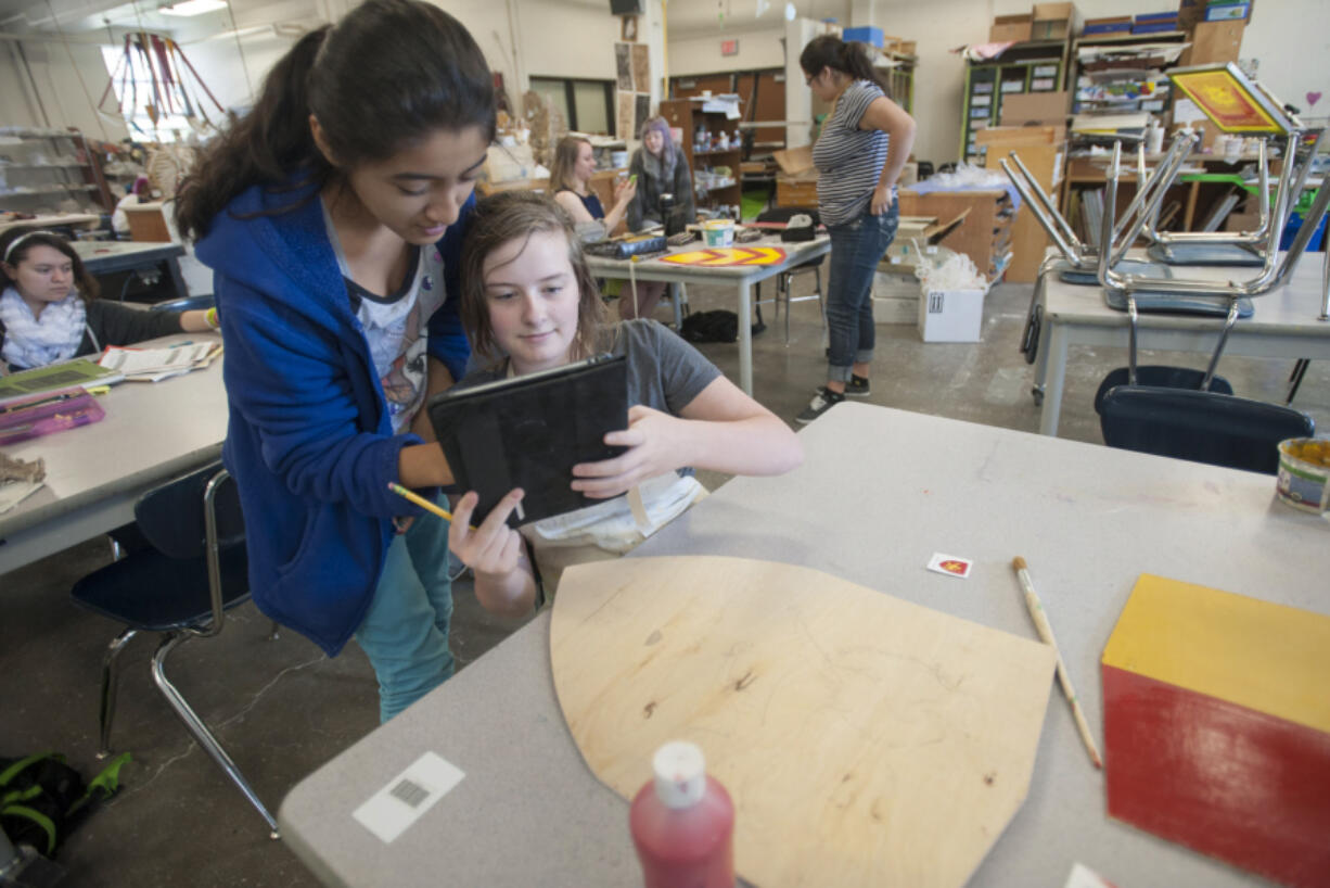 Savanna Falkner, a student at Vancouver School of Arts and Academics, uses an iPad to show a classmate in May 2015 how she will paint the coat of arms of a 13th-century English nobleman who was part of the Magna Carta effort.