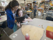 Savanna Falkner, a student at Vancouver School of Arts and Academics, uses an iPad to show a classmate in May 2015 how she will paint the coat of arms of a 13th-century English nobleman who was part of the Magna Carta effort.