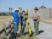 University of Oregon graduate Tim Askin, from left, and University of Idaho grad student Idah Whisenant use surveying equipment with archaeologist Doug Wilson during a July archaeology field-school session at Fort Vancouver National Historic Site.