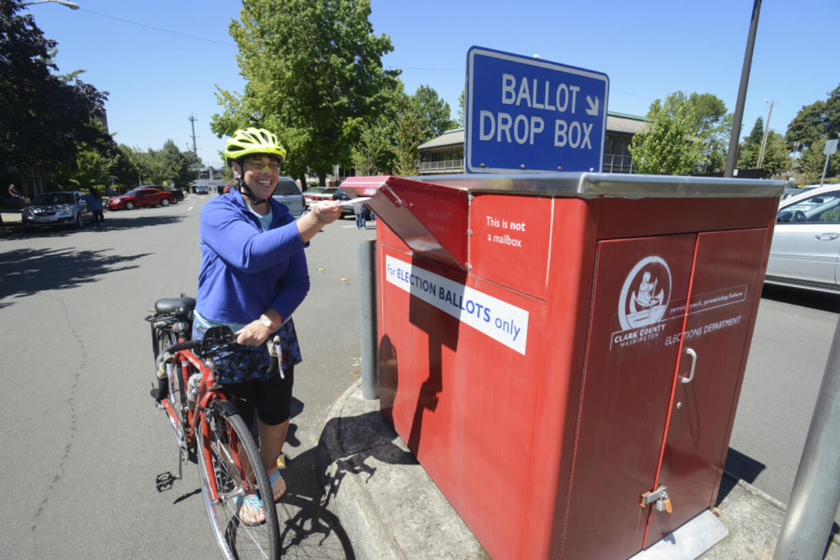 Kelly Cannard drops off her ballot at the ballot drop box Monday on West 14th Street in downtown Vancouver on Monday. Election Day is Tuesday, and voters have until 8 p.m. to submit their ballots in person. Mail-in ballots must be postmarked by Tuesday.