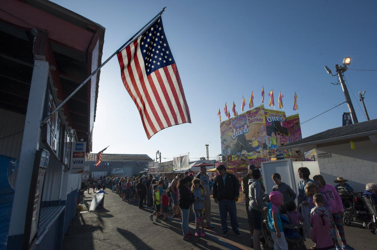 An American flag flies overhead as a long line of people wait for their pancake breakfast Friday morning, the opening day of the 2016 Clark County Fair.