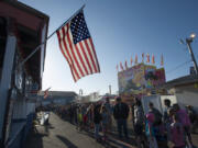 An American flag flies overhead as a long line of people wait for their pancake breakfast Friday morning, the opening day of the 2016 Clark County Fair.