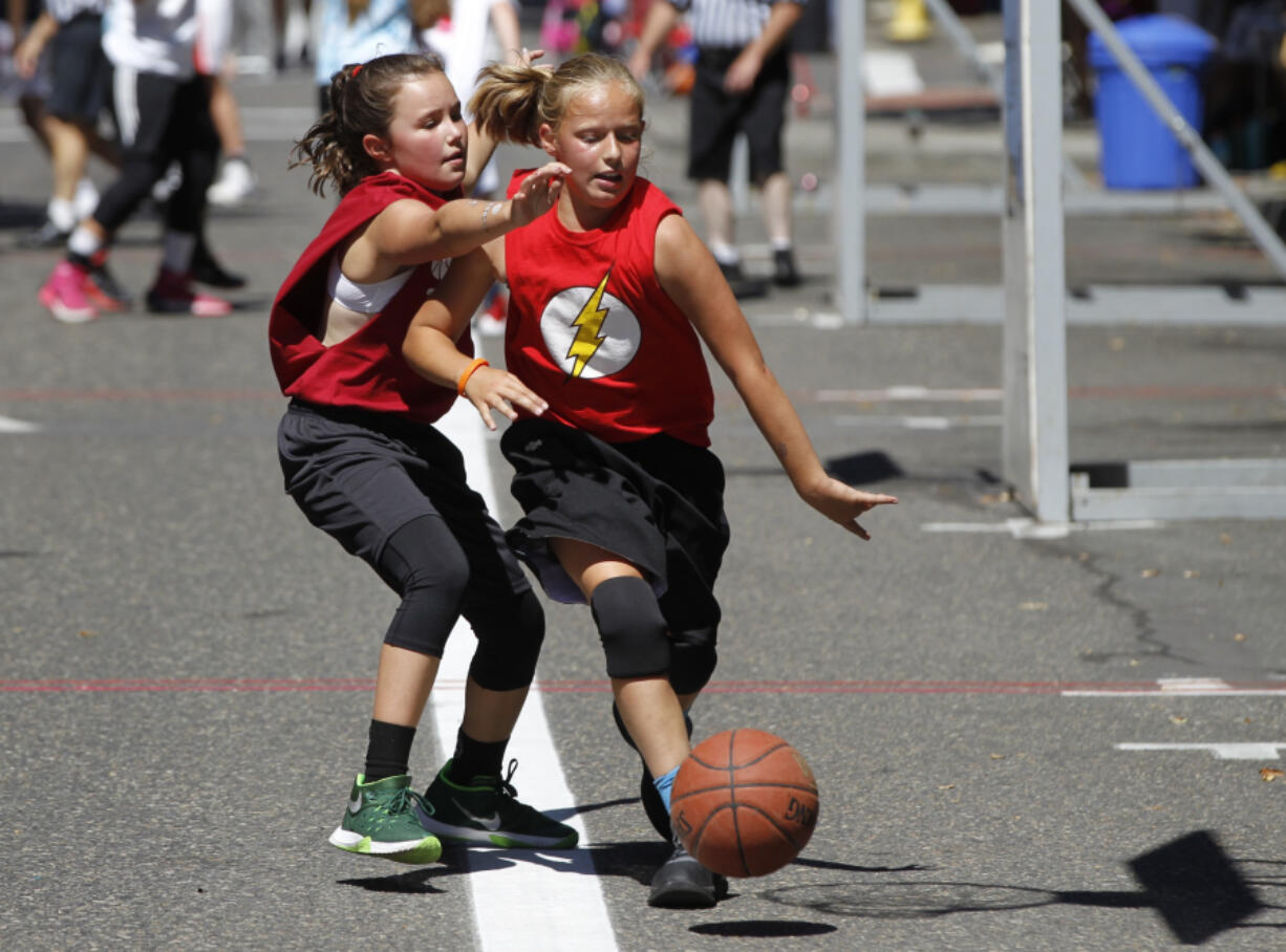 Dylan Mogel, right, of Canby, Ore., drives to the basket with McKenna Reed, left, of Oregon City, Ore., defending, at the Hoops on the River basketball tournament Saturday at Esther Short Park, where players, spectators and organizers dealt with record temperatures. For more details on the weather and the week&#039;s forecast, see Page B8.