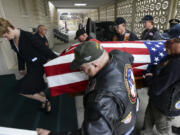 Led by funeral director Leigh Mullen, left, Patriot Guard Riders carry the remains of Army Pfc. William Butz into the Vancouver Funeral Chapel on Tuesday. People can pay their respects today and Thursday from 9 a.m. to 4 p.m.