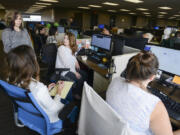 Michelle Hampton, manager of project research at DiscoverOrg in Vancouver, left, chats with employee Savannah King, center, and other team members at DiscoverOrg, which announced it will hire 200 new employees in the next year after more than doubling its staff in 2015.