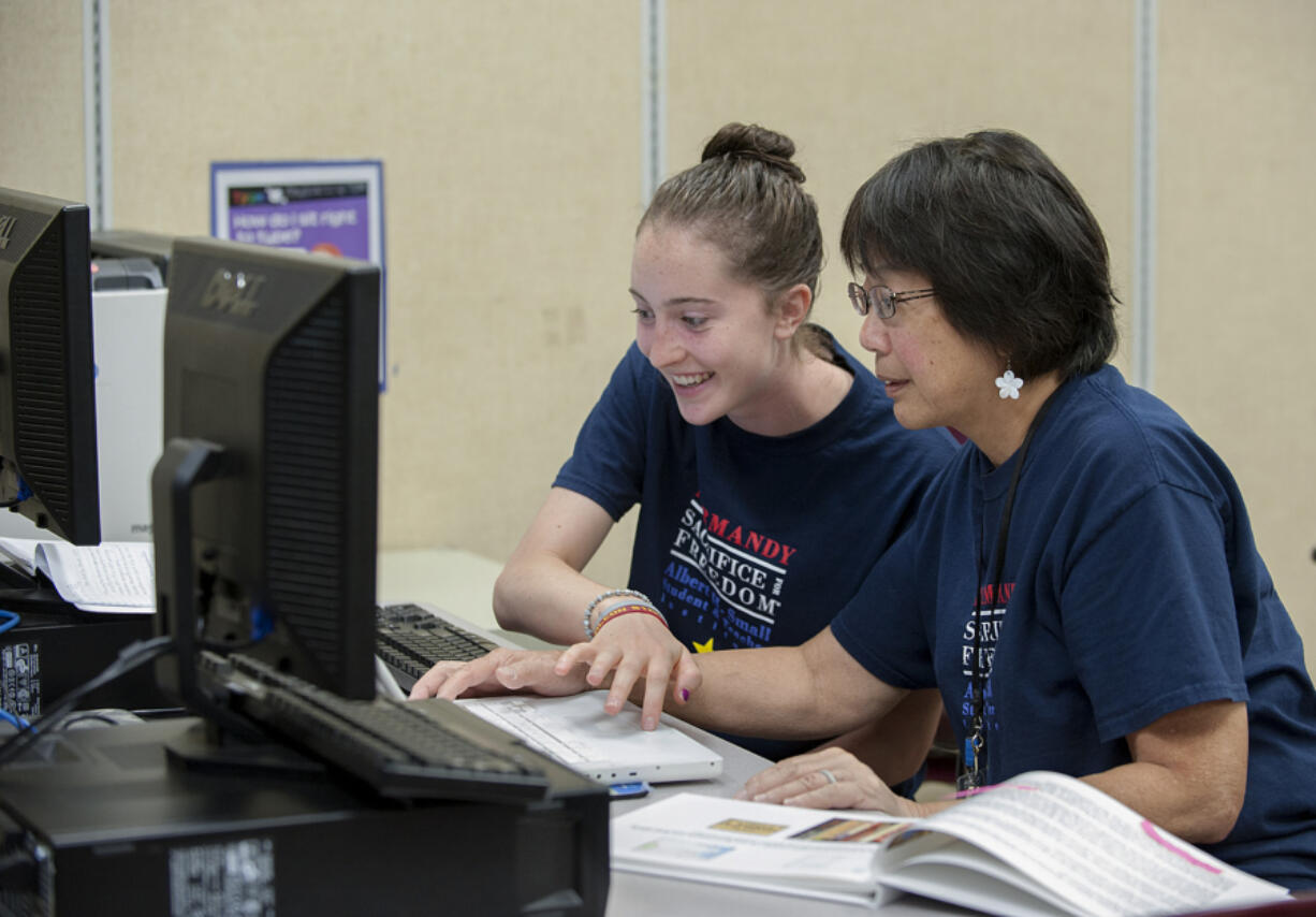 Ally Orr, 16, left, and middle school teacher Irene Soohoo fact-check an item on the website that is part of Orr&#039;s research project on a Hoquiam soldier who died in the D-Day invasion.