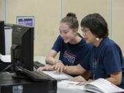 Ally Orr, 16, left, and middle school teacher Irene Soohoo fact-check an item on the website that is part of Orr&#039;s research project on a Hoquiam soldier who died in the D-Day invasion.