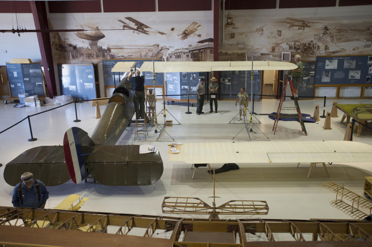 Aircraft restorers re-assemble a DH-4B biplane that had been transported to Pearson Air Museum from Century Aviation in East Wenatchee. It will be unveiled Saturday as Fort Vancouver National Historic Site celebrates the National Park Service centennial.