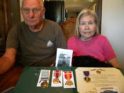 Gary and Betty Hein with the Purple Heart as well as other medals awarded to her brother, Pfc. William Butz, who was killed in Korea in 1950.