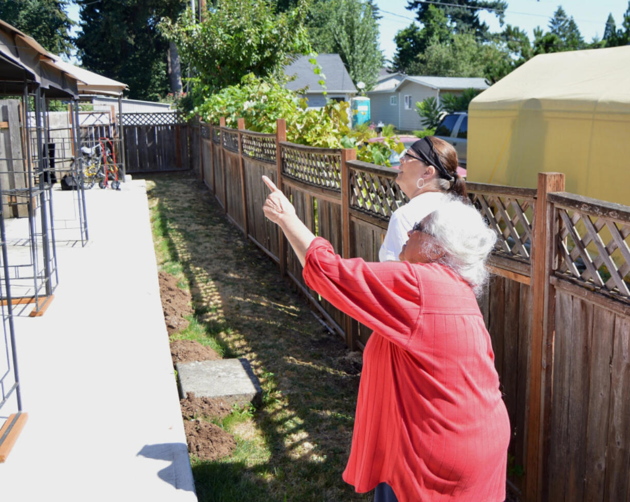 Dolores McClelland points to unwanted wires on the apartment complex she owns in Vancouver&#039;s Maplewood neighborhood.