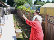 Dolores McClelland points to unwanted wires on the apartment complex she owns in Vancouver&#039;s Maplewood neighborhood.