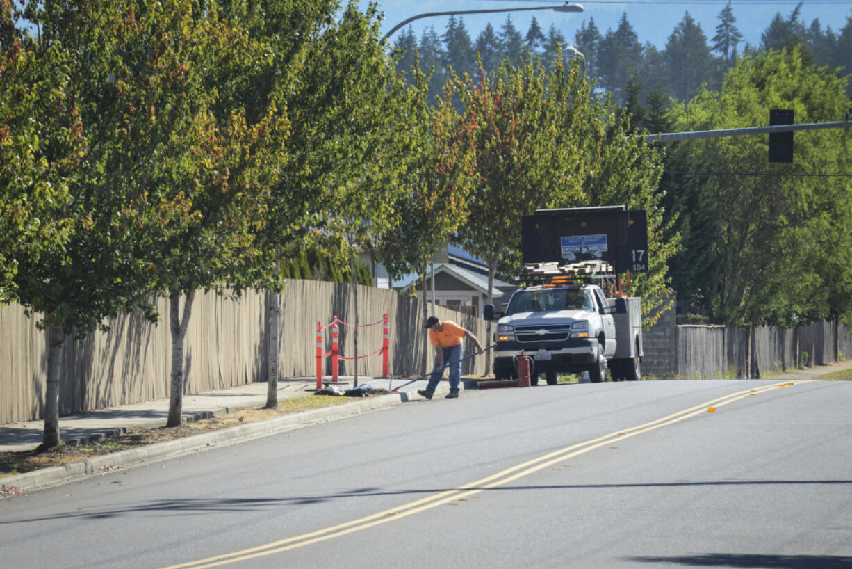 Dean Felts of Allcon Construction LLC works on a C-Tran bus stop Wednesday at Northeast 162nd Avenue and 78th Street in Vancouver. The work is part of a large service change the agency is undergoing.