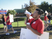 Kosal Sam, a Cascade Middle School sixth-grade math teacher, leads a chant Friday at Evergreen High School for picketers who want contract negotiations.