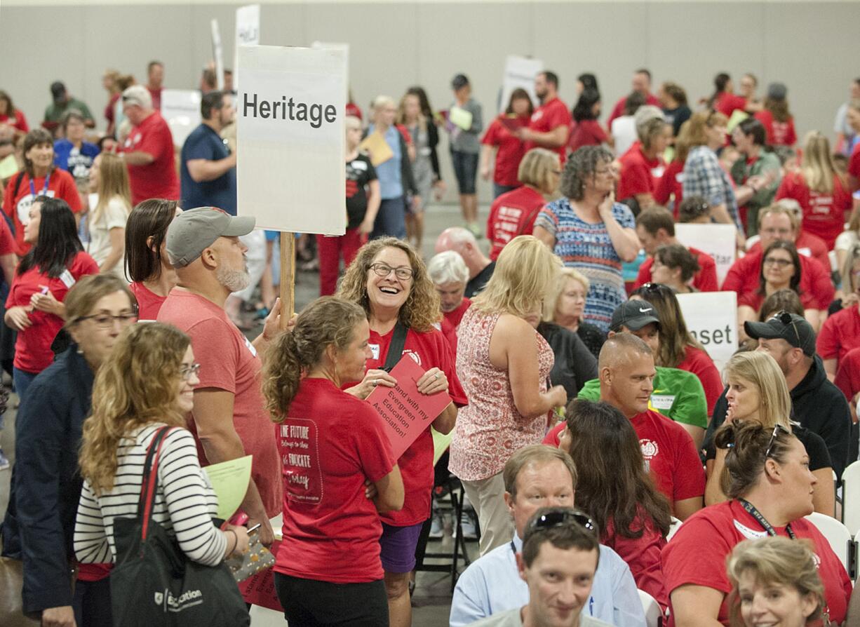 Dozens of teachers fill the Clark County Event Center as they hold signs representing their schools before the start of the meeting Tuesday evening, Aug. 30, 2016.