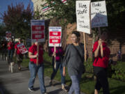 Cecilia Magistrale, in gray, joins her mom, Evergreen Public Schools teacher Angela Magistrale, right, and other pickets Aug. 19 in Southeast Vancouver. The teachers union and the school district are in the midst of contentious contract negotiations.